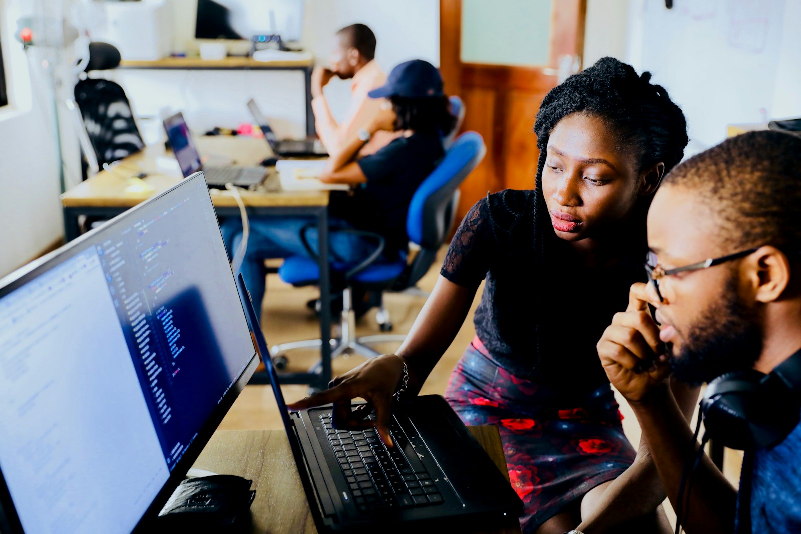 Two learners working together at a laptop in a training space.