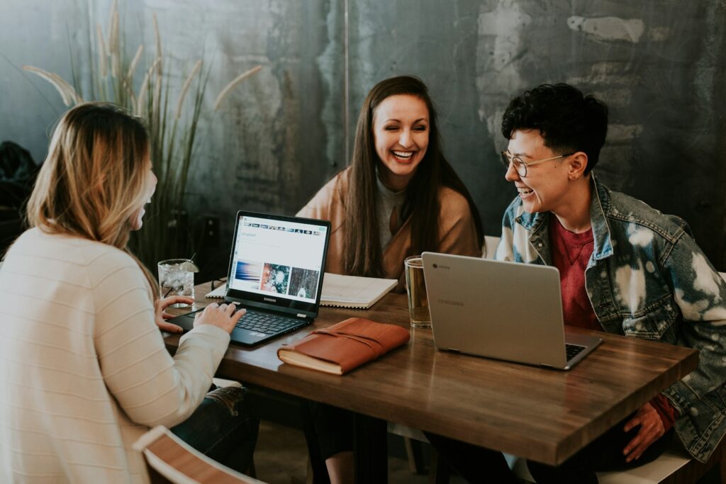 A group of adults discussing work around a laptop.