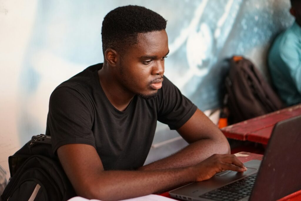 A man practising on a laptop at a shared desk.